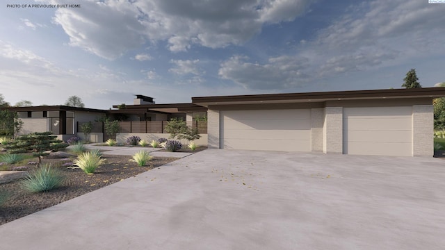 view of front of property with fence, concrete driveway, an attached garage, and brick siding