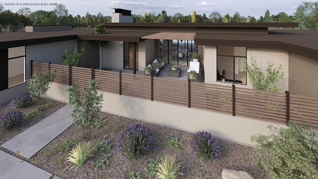 view of home's exterior featuring a fenced front yard, stucco siding, and a chimney