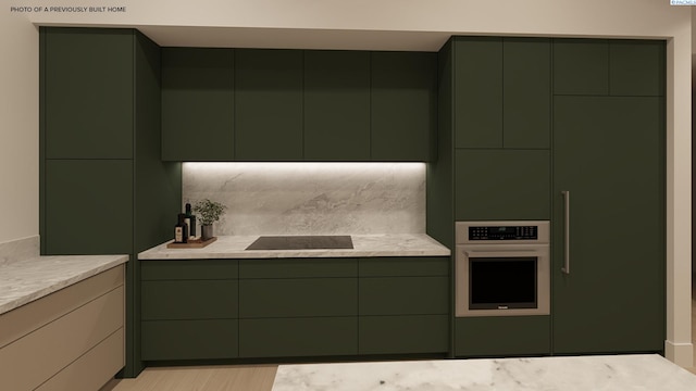 kitchen featuring white oven, light countertops, black electric cooktop, and green cabinets