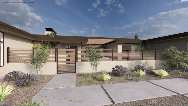 entrance to property with stucco siding and fence
