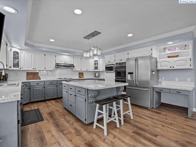 1842 Mahan Ave, Richland, WA 99354 - kitchen featuring a kitchen island, gray cabinetry, under cabinet range hood, appliances with stainless steel finishes, and crown molding