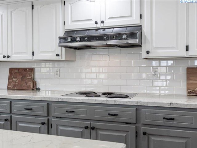 1842 Mahan Ave, Richland, WA 99354 - kitchen with gray cabinets, under cabinet range hood, electric stovetop, white cabinets, and decorative backsplash