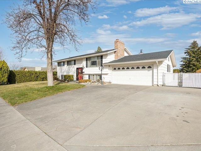 1842 Mahan Ave, Richland, WA 99354 - split foyer home featuring a front lawn, driveway, fence, an attached garage, and a chimney