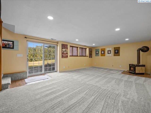 1842 Mahan Ave, Richland, WA 99354 - unfurnished living room with visible vents, baseboards, carpet floors, a wood stove, and recessed lighting