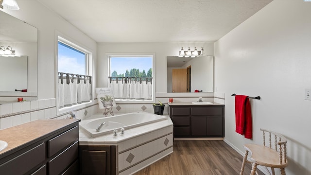 4504 S Dayton Ct, Kennewick, WA 99337 - bathroom featuring two vanities, wood finished floors, and a garden tub