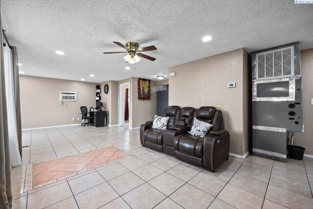 living room featuring a wall mounted air conditioner, a textured ceiling, ceiling fan, and light tile patterned flooring