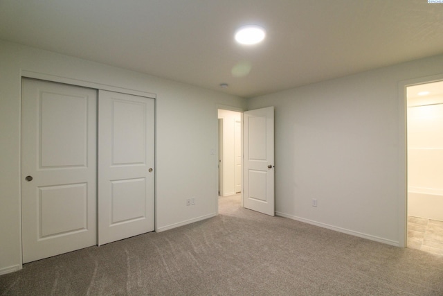 unfurnished bedroom featuring light colored carpet and a closet