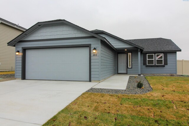 ranch-style home featuring a garage and a front yard