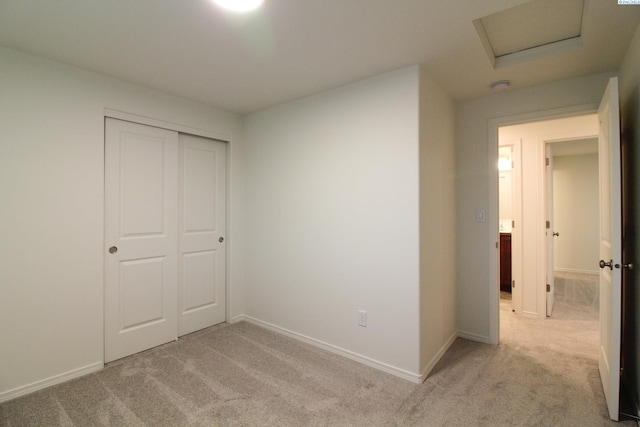 unfurnished bedroom with a closet and light carpet