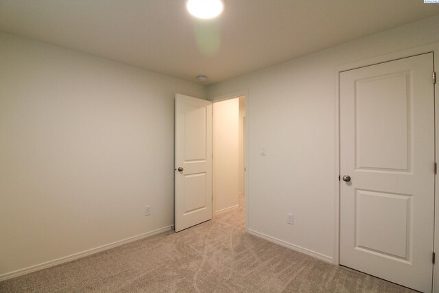 unfurnished bedroom featuring light carpet