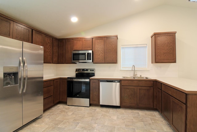 kitchen with sink, vaulted ceiling, kitchen peninsula, and appliances with stainless steel finishes