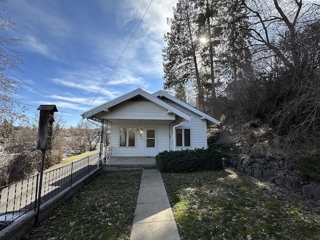 bungalow-style house with a porch and fence