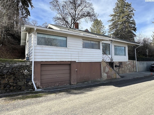 view of front facade featuring a garage and a chimney