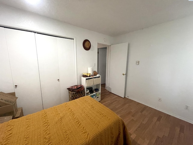 bedroom featuring baseboards, a closet, and wood finished floors