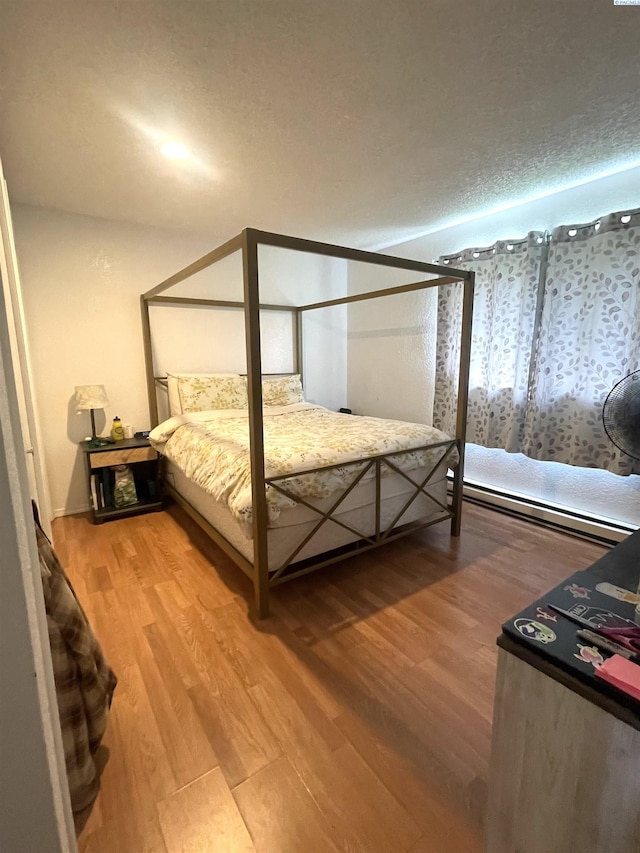 bedroom featuring a textured ceiling and light wood-style floors
