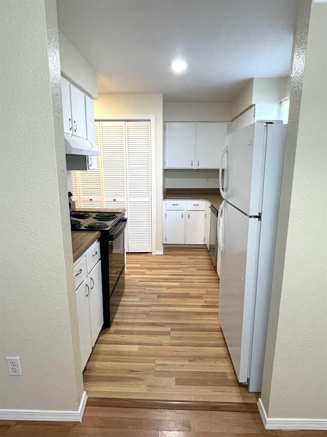 kitchen with freestanding refrigerator, dishwasher, under cabinet range hood, a textured wall, and black range with electric stovetop
