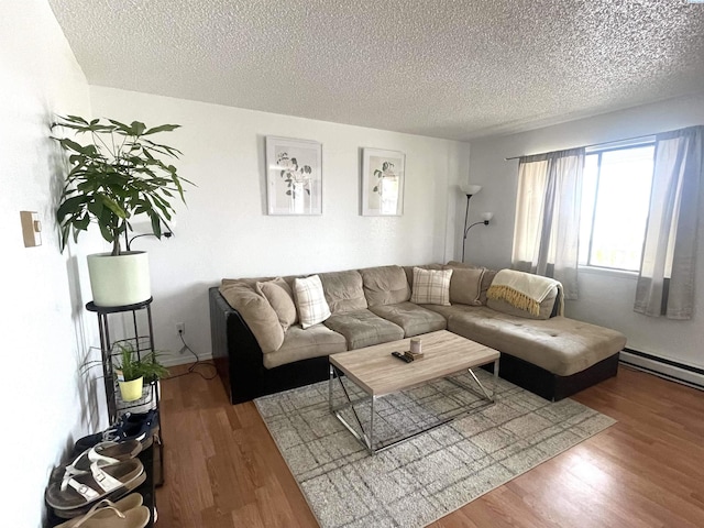 living area with a baseboard radiator, a textured ceiling, and wood finished floors