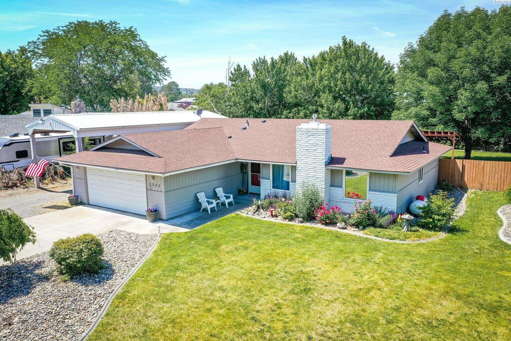 2332 S Tacoma St, Kennewick, WA 99337 - ranch-style house with a chimney, an attached garage, a shingled roof, and driveway