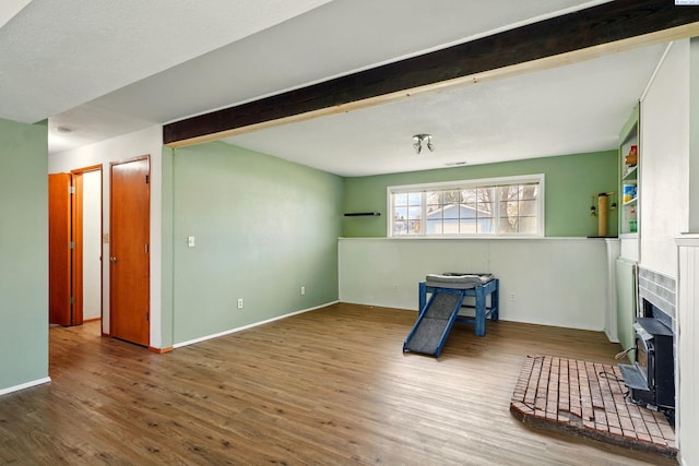 1584 Cimarron Ave, Richland, WA 99352 - living area featuring a wainscoted wall, beamed ceiling, a wood stove, and wood finished floors