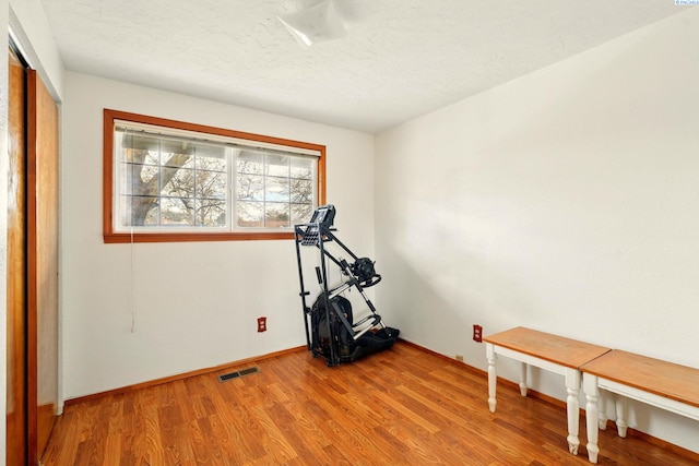 1584 Cimarron Ave, Richland, WA 99352 - exercise area featuring light wood-style floors, baseboards, visible vents, and a textured ceiling
