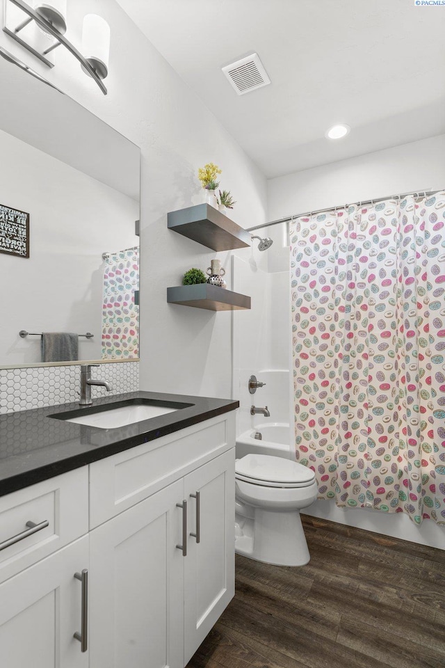 full bath with shower / bath combination with curtain, toilet, wood finished floors, visible vents, and vanity