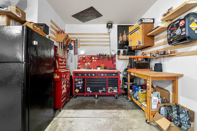 garage with a workshop area and freestanding refrigerator
