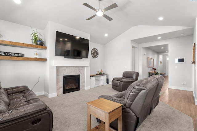 living area with a tile fireplace, baseboards, lofted ceiling, and a ceiling fan