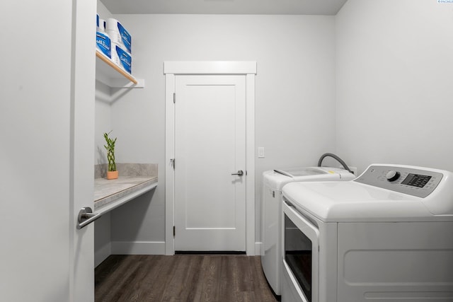 laundry room featuring separate washer and dryer, laundry area, dark wood-style flooring, and baseboards
