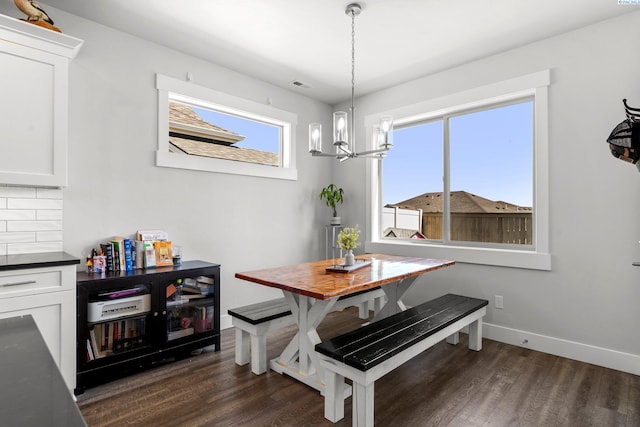 dining space with an inviting chandelier, visible vents, baseboards, and dark wood-style floors
