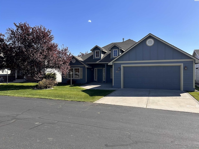 view of front facade featuring board and batten siding, a front lawn, driveway, and an attached garage