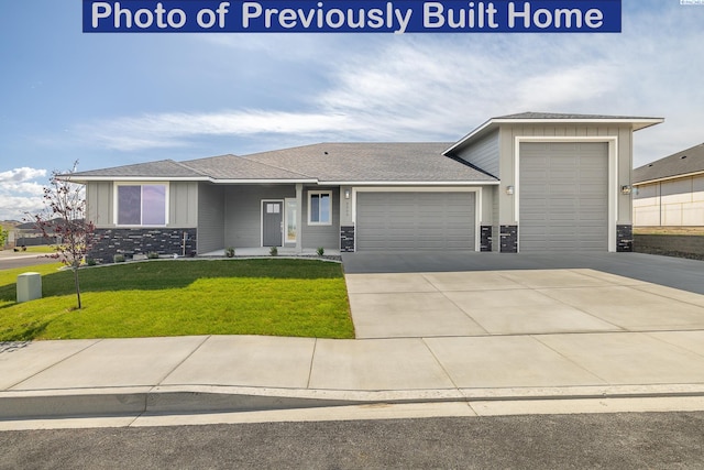 view of front of house with a garage, driveway, a front lawn, and roof with shingles