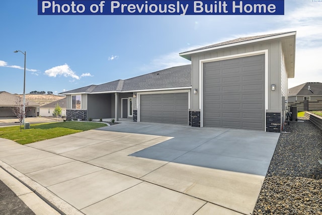 view of front of home featuring a garage, a front yard, and concrete driveway