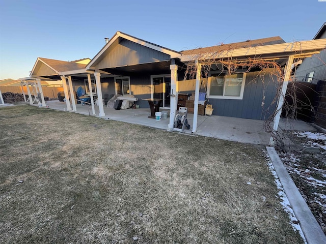 rear view of property featuring a patio area and a lawn