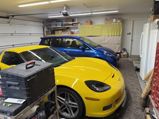 garage featuring a garage door opener and freestanding refrigerator