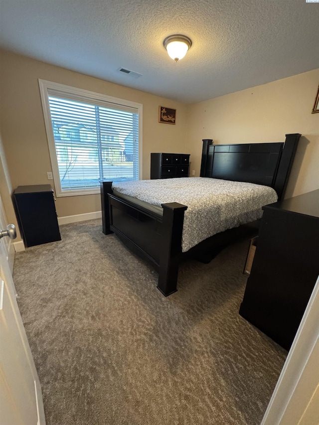 carpeted bedroom featuring visible vents, baseboards, and a textured ceiling