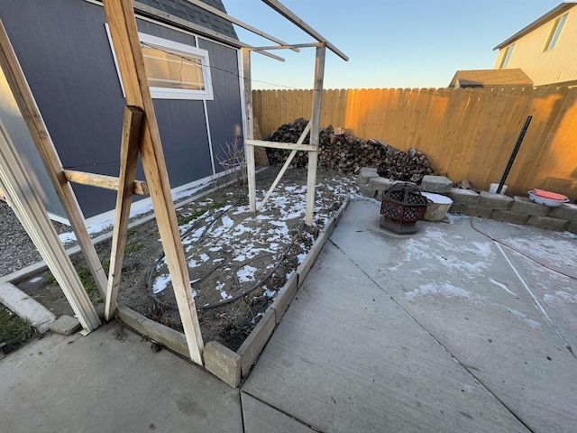 view of patio featuring fence and a fire pit