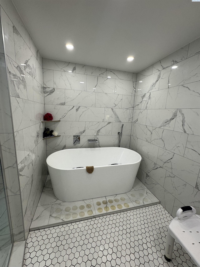 bathroom featuring recessed lighting, a freestanding bath, and tile walls