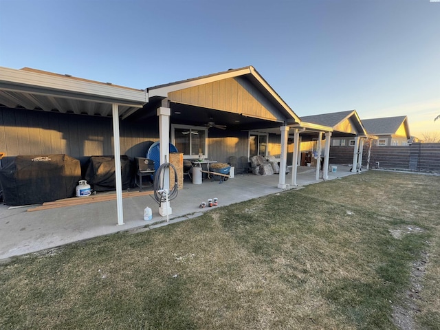 rear view of property with a patio, a lawn, a ceiling fan, and fence