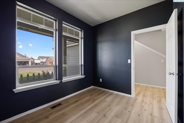 spare room with wood finished floors and baseboards