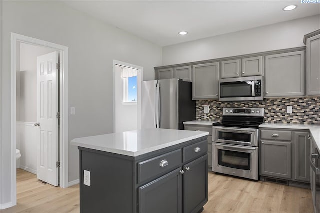 kitchen with stainless steel appliances, gray cabinets, decorative backsplash, light countertops, and recessed lighting