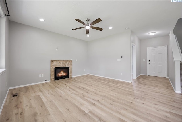 unfurnished living room featuring a ceiling fan, light wood finished floors, a fireplace, baseboards, and recessed lighting