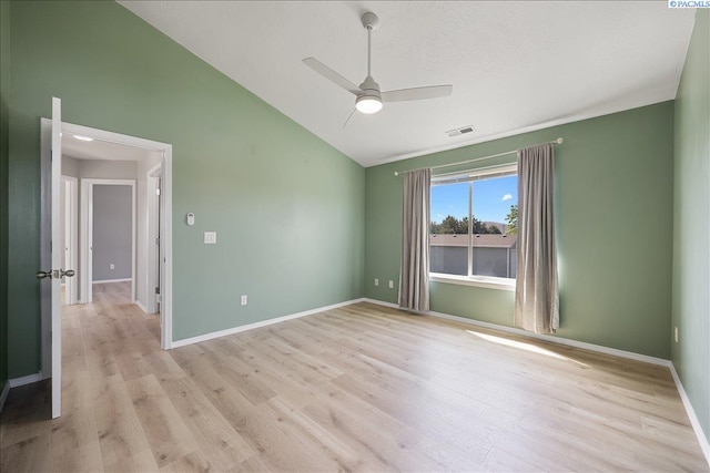 spare room with lofted ceiling, light wood-style flooring, ceiling fan, and baseboards