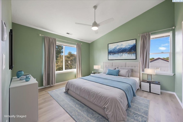 bedroom featuring vaulted ceiling, light wood-style floors, baseboards, and a ceiling fan