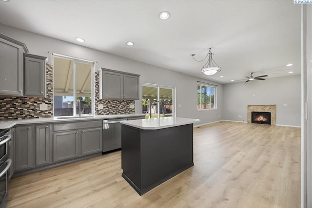 kitchen featuring gray cabinetry, stainless steel appliances, a sink, a ceiling fan, and recessed lighting