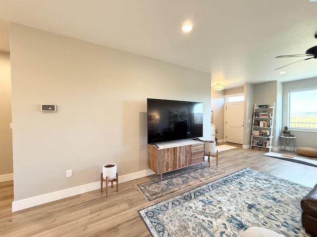 living area featuring light wood-style floors, ceiling fan, baseboards, and recessed lighting