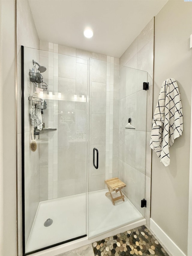 full bathroom with a stall shower and baseboards