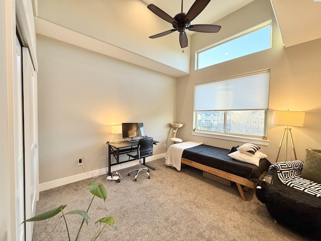 carpeted bedroom with a high ceiling, multiple windows, baseboards, and a ceiling fan