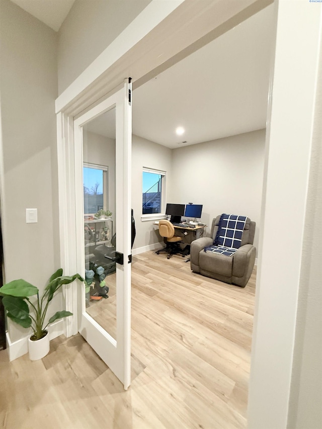 interior space with french doors, light wood-style flooring, and baseboards