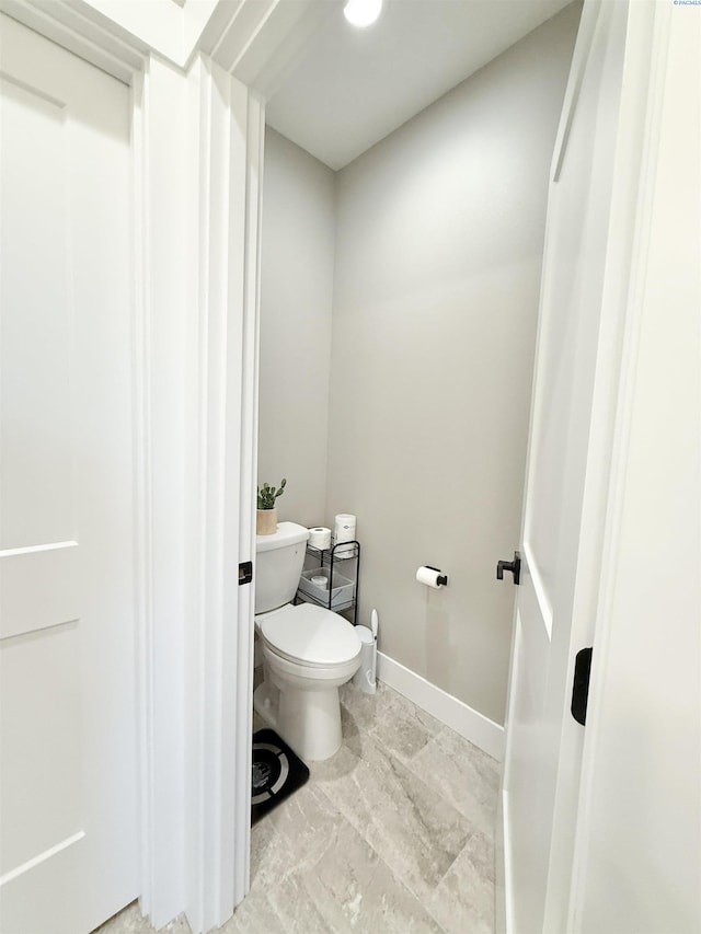 bathroom featuring toilet and baseboards