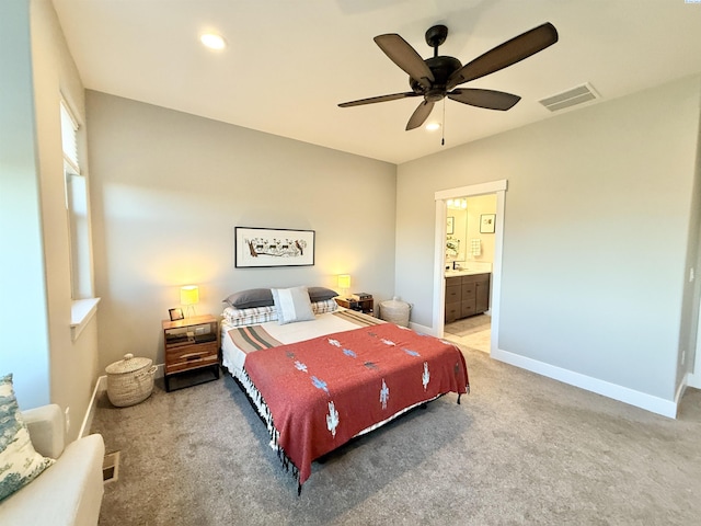 bedroom featuring recessed lighting, light colored carpet, visible vents, baseboards, and ensuite bath